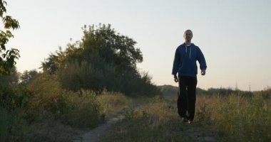 Genç Adam Yürüyüşü Doğanın tadını çıkarıyor Sabah 4K 10-bit