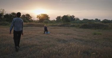 Man and Boy, Oyuncak Uçakla Sahada Oynuyor. Baba ve Çocuk Doğa 4K 10-bit 'te Birlikte Zaman Geçiriyorlar