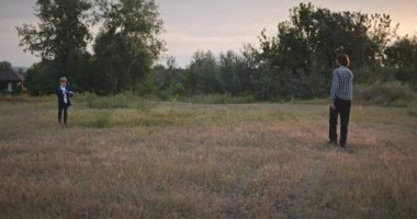 Man and Boy, Oyuncak Uçakla Sahada Oynuyor. Baba ve Çocuk Doğa 4K 10-bit 'te Birlikte Zaman Geçiriyorlar