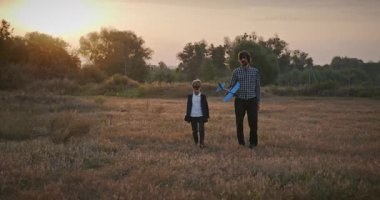 Man and Boy, Oyuncak Uçakla Sahada Oynuyor. Baba ve Çocuk Doğa 4K 10-bit 'te Birlikte Zaman Geçiriyorlar