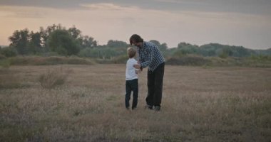 Man and Boy sahada koşuyor. Baba ve Çocuk Doğa 4K 10-bit 'te Birlikte Zaman Geçiriyorlar