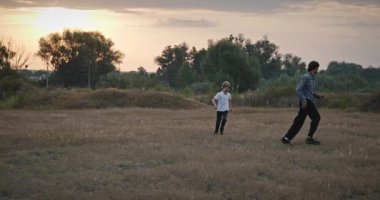 Man and Boy sahada koşuyor. Baba ve Çocuk Doğa 4K 10-bit 'te Birlikte Zaman Geçiriyorlar
