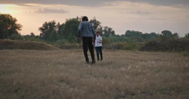 Man and Boy sahada koşuyor. Baba ve Çocuk Doğa 4K 10-bit 'te Birlikte Zaman Geçiriyorlar