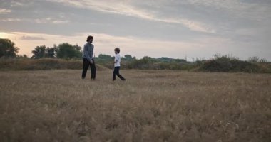 Man and Boy sahada koşuyor. Baba ve Çocuk Doğa 4K 10-bit 'te Birlikte Zaman Geçiriyorlar