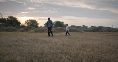 Man and Boy sahada koşuyor. Baba ve Çocuk Doğa 4K 10-bit 'te Birlikte Zaman Geçiriyorlar