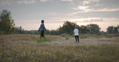 Man and Boy sahada koşuyor. Baba ve Çocuk Doğa 4K 10-bit 'te Birlikte Zaman Geçiriyorlar