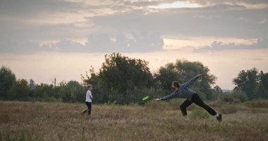 İnsan ve Çocuk Uçan Disk Fırlatıyor. Baba ve Çocuk Birlikte Oynuyor Doğa 4K 10-bit 'te Zaman Geçiriyorlar