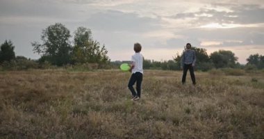 İnsan ve Çocuk frizbi fırlatıyor. Baba ve Çocuk Birlikte Oynuyor Doğa 4K 10-bit 'te Zaman Geçiriyorlar