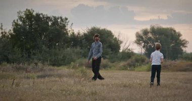 İnsan ve Çocuk frizbi fırlatıyor. Baba ve Çocuk Birlikte Oynuyor Doğa 4K 10-bit 'te Zaman Geçiriyorlar