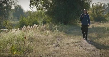 Genç Adam Yürüyüşü Doğanın tadını çıkarıyor Sabah 4K 10-bit