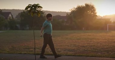 Çocuk futbol sahasında antrenman yapıyor. Çocuk Sabah Egzersizi Yapıyor Dışarıda 4K 10-bit Yavaş çekim 60 fps