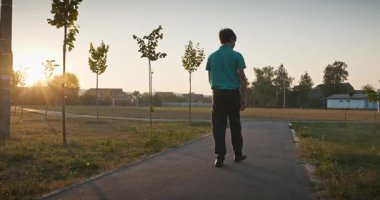 Futbol sahasında erkek yürüyüşü. Çocuk Sabah Egzersizi Yapıyor Dışarıda 4K 10-bit Yavaş çekim 60 fps