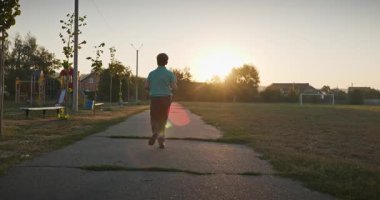Futbol sahasında koşan çocuk. Çocuk Sabah Egzersizi Yapıyor Dışarıda 4K 10-bit Yavaş çekim 60 fps