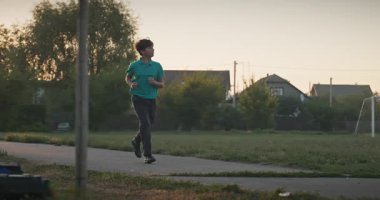 Futbol sahasında koşan çocuk. Çocuk Sabah Egzersizi Yapıyor Dışarıda 4K 10-bit Yavaş çekim 60 fps