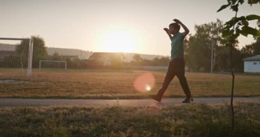 Çocuk futbol sahasında antrenman yapıyor. Çocuk Sabah Egzersizi Yapıyor Dışarıda 4K 10-bit Yavaş çekim 60 fps