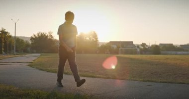 Futbol sahasında erkek yürüyüşü. Çocuk Sabah Egzersizi Yapıyor Dışarıda 4K 10-bit Yavaş çekim 60 fps