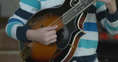 Beyaz çocuk evde Mandolin oynuyor. Avrupalı Çocuk Müzik Çalışması 4K 10-bit