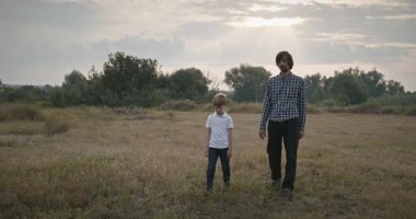 Adam ve Çocuk Sahada Konuşuyor. Baba ve Çocuk Doğa 4K 10-bit 'te Birlikte Zaman Geçiriyorlar