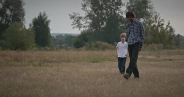 Adam ve Çocuk Sahada Konuşuyor. Baba ve Çocuk Doğa 4K 10-bit 'te Birlikte Zaman Geçiriyorlar