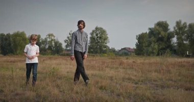 Adam ve Çocuk Sahada Konuşuyor. Baba ve Çocuk Doğa 4K 10-bit 'te Birlikte Zaman Geçiriyorlar