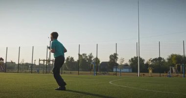 Futbol sahasında koşan çocuk. Çocuk Sabah Egzersizi Yapıyor Dışarıda 4K 10-bit Yavaş çekim 60 fps