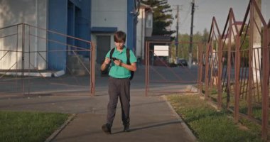 Çocuk Akıllı Telefon Kullan Oyun sahasında Yürüyüş 4K 10-bit Yavaş çekim 60 fps