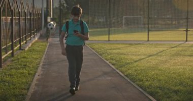 Çocuk Akıllı Telefon Kullan Oyun sahasında Yürüyüş 4K 10-bit Yavaş çekim 60 fps