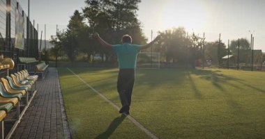 Çocuk futbol sahasında antrenman yapıyor. Çocuk Sabah Egzersizi Yapıyor Dışarıda 4K 10-bit Yavaş çekim 60 fps