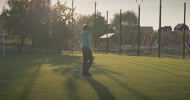 Çocuk futbol sahasında antrenman yapıyor. Çocuk Sabah Egzersizi Yapıyor Dışarıda 4K 10-bit Yavaş çekim 60 fps