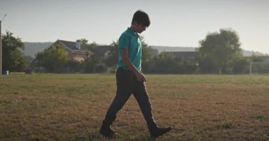 Futbol sahasındaki çocuk yürüyüşü futbol sahasında gezinti 4K 10-bit ağır çekim 60 fps