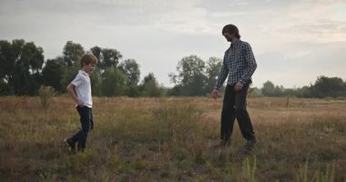 Adam ve Çocuk Sahada Konuşuyor. Baba ve Çocuk Doğa 4K 10-bit 'te Birlikte Zaman Geçiriyorlar