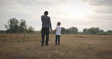 Adam ve Çocuk Sahada Konuşuyor. Baba ve Çocuk Doğa 4K 10-bit 'te Birlikte Zaman Geçiriyorlar