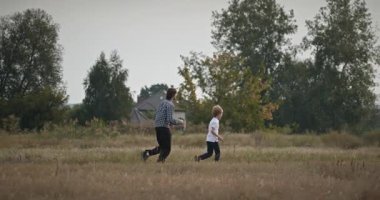 Man and Boy sahada koşuyor. Baba ve Çocuk Doğa 4K 10-bit 'te Birlikte Zaman Geçiriyorlar