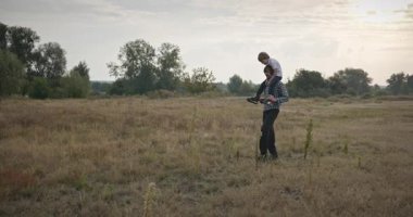 Mutlu Adam, çocuğu omuzlarında taşıyor. Baba ve Çocuk Doğa 4K 10-bit 'te Birlikte Zaman Geçiriyorlar