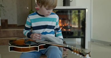Beyaz çocuk evde Mandolin oynuyor. Avrupalı Çocuk Müzik Çalışması 4K 10-bit