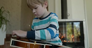 Beyaz çocuk evde Mandolin oynuyor. Avrupalı Çocuk Müzik Çalışması 4K 10-bit