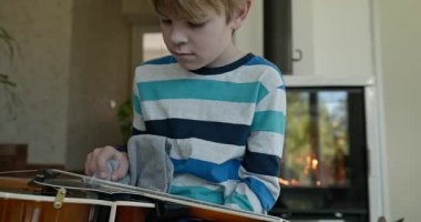 Beyaz çocuk evde Mandolin oynuyor. Avrupalı Çocuk Müzik Çalışması 4K 10-bit