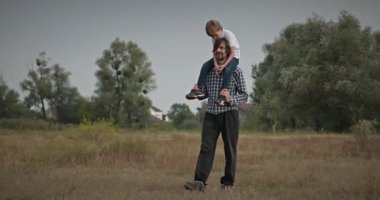 Mutlu Adam, çocuğu omuzlarında taşıyor. Baba ve Çocuk Doğa 4K 10-bit 'te Birlikte Zaman Geçiriyorlar