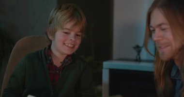 Çocuk, amcası ve babasıyla birlikte müzik dinleyip 4K 10-bit 'lik aile albümü izliyor.