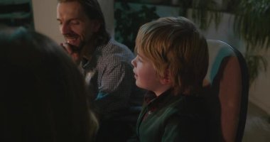 Amcası ve babası olan bir çocuk heyecanlı bir kitap okuyor. 4K 10-bit eğleniyor.