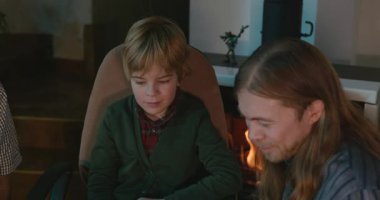 Amcası ve babası olan bir çocuk heyecanlı bir kitap okuyor. 4K 10-bit eğleniyor.