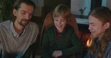 Amcası ve babası olan bir çocuk heyecanlı bir kitap okuyor. 4K 10-bit eğleniyor.