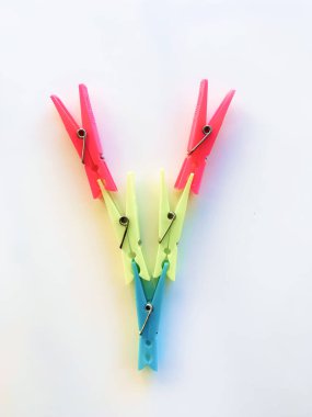 Çamaşırları dışarı asmak için plastik renkli mandallar. Plaj havlusu mandalları, havlu tutacağı, plastik giysi askıları, askı tutacağı, kıskaçlar, mandallar. Beyaz arkaplanda