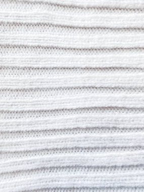 Örgü ve kıvrımlı beyaz yün süveter. Kumaş arkaplanı.