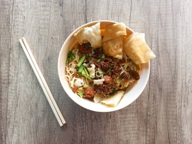 Bir kase tavuk eriştesi kraker, doğranmış et ve taze sebzelerle birlikte hazır..