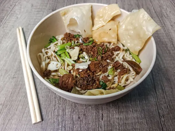 Ahşap bir tabakta nefis bir tavuklu erişte servisi..