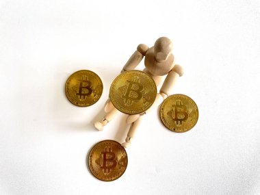 Beyaz arka planda Bitcoin altın taşıyan tahta manken kavramı.