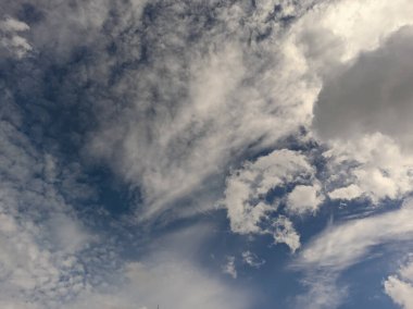 Dramatic blue sky with fluffy white clouds in natural daylight. clipart