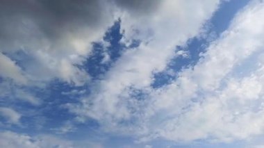 Açık mavi gökyüzüne karşı yumuşak beyaz bulutların geniş görüşü.