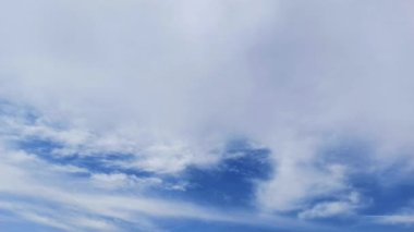 Parlak mavi gökyüzü, güzel güneşli bir havada dağınık beyaz bulutlar..